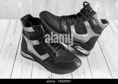 Confortevole sneakers nero con pannelli grigio su una piattaforma elevata con una cerniera lampo e lace-up. Immagine in bianco e nero Foto Stock