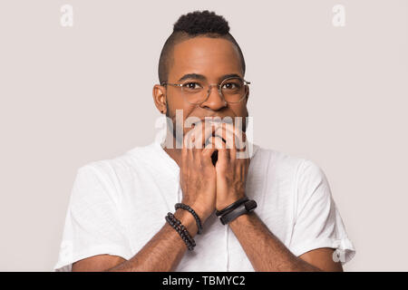 Stanco uomo nero in piedi in studio testa a pelo sulle mani Foto Stock