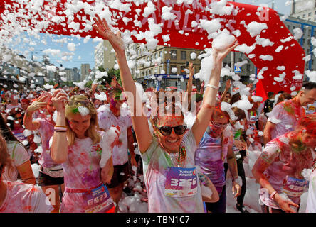 Ai partecipanti di essere irrorato con colori durante l'evento. Il Colour Run, noto anche come "il più felice 5.000 metri sul nostro pianeta", è una serie di eventi e di vernice gara, il suo primo evento è stato negli Stati Uniti nel mese di gennaio 2012 da allora la corsa si è diffusa in tutto il mondo, lasciando una scia di colore e felice corridori di diversi continenti e paesi. L'evento senza orario non ha vincitori o premi, ma i runner sono salutati con polvere colorata, fatta di grado alimentare amido di mais, in corrispondenza delle stazioni lungo il percorso. Nella capitale Ucraina la prima volta Kyiv Colour Run è iniziata nel 2014. Foto Stock