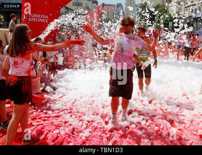 Ai partecipanti di essere irrorato con colori durante l'evento. Il Colour Run, noto anche come "il più felice 5.000 metri sul nostro pianeta", è una serie di eventi e di vernice gara, il suo primo evento è stato negli Stati Uniti nel mese di gennaio 2012 da allora la corsa si è diffusa in tutto il mondo, lasciando una scia di colore e felice corridori di diversi continenti e paesi. L'evento senza orario non ha vincitori o premi, ma i runner sono salutati con polvere colorata, fatta di grado alimentare amido di mais, in corrispondenza delle stazioni lungo il percorso. Nella capitale Ucraina la prima volta Kyiv Colour Run è iniziata nel 2014. Foto Stock