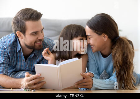 Amare i genitori godetevi il relax di lettura con piccola figlia Foto Stock