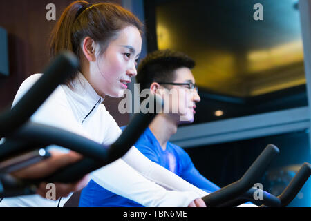Giovani asiatici persone che lavorano in una palestra moderna Foto Stock