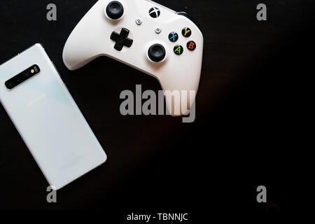 Un telefono e il controller seduti fianco a fianco come diventa gioco multi-piattaforma Foto Stock