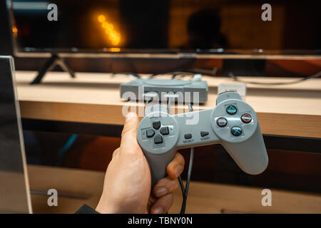 Maschio di mani tenendo il vecchio un controller PS2 Foto Stock