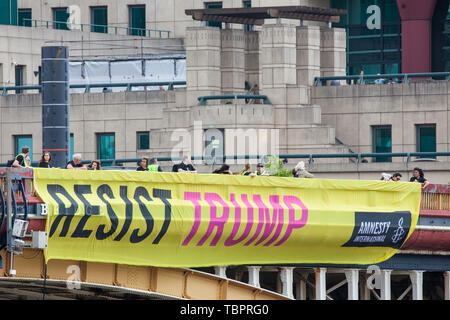 Londra, Regno Unito. Il 3 giugno, 2019. Uno dei cinque colori vivaci dei banner recanti gli slogan "Resistere Trump', 'resistere sessismo', 'resistere al razzismo", "resistere odio' e 'resistere alla crudeltà' è sceso da Vauxhall Bridge in vista dell'ambasciata Usa dagli attivisti di Amnesty International all'inizio del presidente Donald Trump's tre giorni di visita di Stato nel Regno Unito. Amnesty International ha scritto al Primo Ministro Theresa Maggio ha scritto al Theresa Maggio di incitarla a sollevare le questioni relative ai diritti umani direttamente con il Presidente degli Stati Uniti. Credito: Mark Kerrison/Alamy Live News Foto Stock