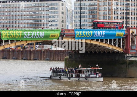 Londra, Regno Unito. Il 3 giugno, 2019. Due dei cinque colori vivaci dei banner recanti gli slogan "Resistere Trump', 'resistere sessismo', 'resistere al razzismo", "resistere odio' e 'resistere alla crudeltà' sono sceso da Vauxhall Bridge in vista dell'ambasciata Usa dagli attivisti di Amnesty International all'inizio del presidente Donald Trump's tre giorni di visita di Stato nel Regno Unito. Amnesty International ha scritto al Primo Ministro Theresa Maggio ha scritto al Theresa Maggio di incitarla a sollevare le questioni relative ai diritti umani direttamente con il Presidente degli Stati Uniti. Credito: Mark Kerrison/Alamy Live News Foto Stock