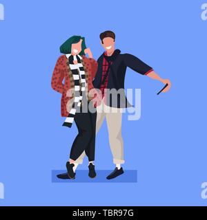 Giovane tenendo selfie foto sulla fotocamera dello smartphone casual uomo donna in piedi insieme maschio femmina i personaggi dei cartoni animati che pongono sfondo blu pieno piatto Illustrazione Vettoriale