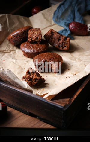 In a brown wooden frame, a small piece of brown sugar red jujube cake wrapped on kraft paper Foto Stock