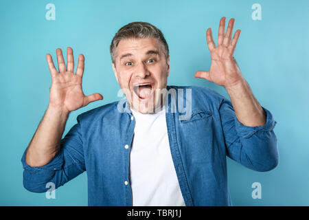 Urlando uomo maturo sul colore di sfondo Foto Stock