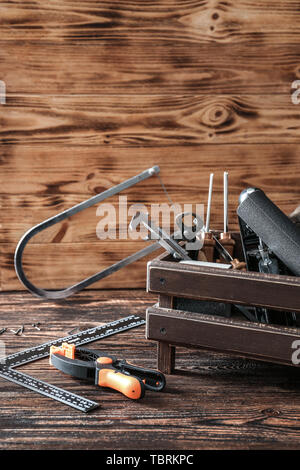 Scatola con set di falegname utensili su sfondo di legno Foto Stock