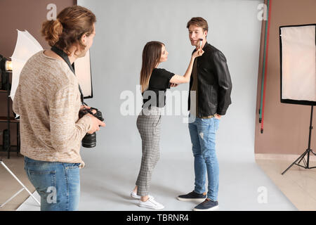 Fotografo, trucco artisti e il modello in studio moderno Foto Stock