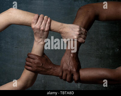 Gare uniti contro la discriminazione e il razzismo. Il nero americano africano e Caucasico mani tenendo insieme nel mondiale di unità e di amore razziale e underst Foto Stock