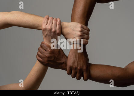 Gare uniti contro la discriminazione e il razzismo. Il nero americano africano e Caucasico mani tenendo insieme nel mondiale di unità e di amore razziale e underst Foto Stock