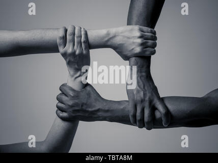 Gare uniti contro la discriminazione e il razzismo. Il nero americano africano e Caucasico mani tenendo insieme nel mondiale di unità e di amore razziale e underst Foto Stock