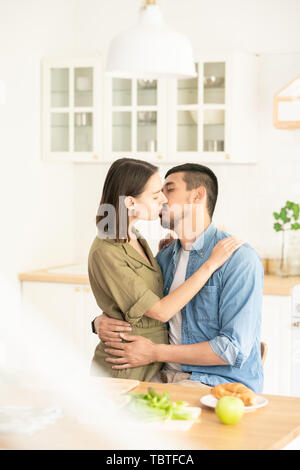 Kissing in cucina Foto Stock