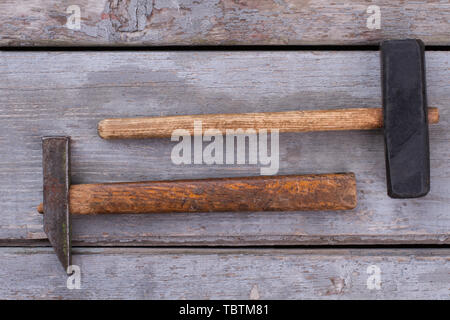 Due martelli su sfondo di legno. Strumenti per la costruzione o la riparazione. In stile vintage. Foto Stock