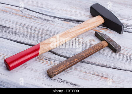 Vecchio e nuovo martelli su sfondo di legno. Martelli con manici di legno sulla superficie di legno. Foto Stock