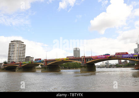 Attivista di Amnesty International distendere anti-Trump banner da Vauxhall Bridge in vista dell'Ambasciata degli Stati Uniti a Londra centrale, il giorno uno di noi presidente Donald Trump's visita di Stato nel Regno Unito. Foto Stock