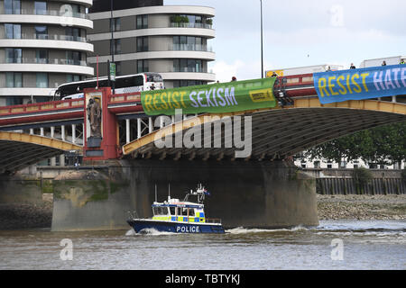 Attivista di Amnesty International distendere anti-Trump banner da Vauxhall Bridge in vista dell'Ambasciata degli Stati Uniti a Londra centrale, il giorno uno di noi presidente Donald Trump's visita di Stato nel Regno Unito. Foto Stock