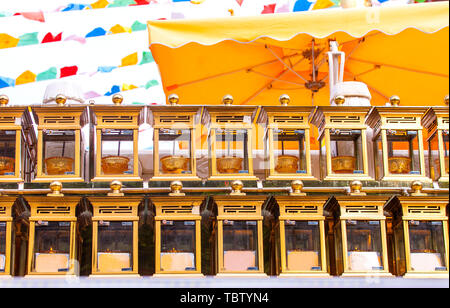 Candela di colore giallo sul piedistallo in metallo al tempio per il culto del buddismo. Foto Stock