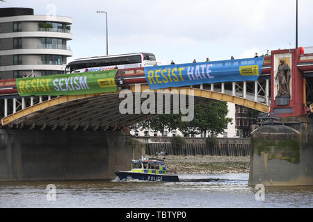 Attivista di Amnesty International distendere anti-Trump banner da Vauxhall Bridge in vista dell'Ambasciata degli Stati Uniti a Londra centrale, il giorno uno di noi presidente Donald Trump's visita di Stato nel Regno Unito. Foto Stock