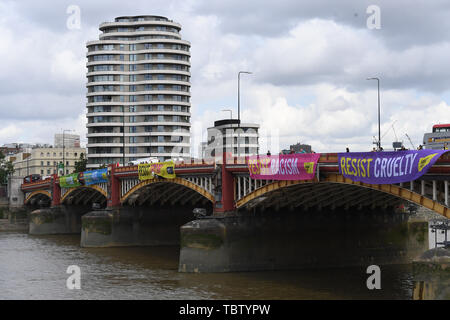 Attivista di Amnesty International distendere anti-Trump banner da Vauxhall Bridge in vista dell'Ambasciata degli Stati Uniti a Londra centrale, il giorno uno di noi presidente Donald Trump's visita di Stato nel Regno Unito. Foto Stock