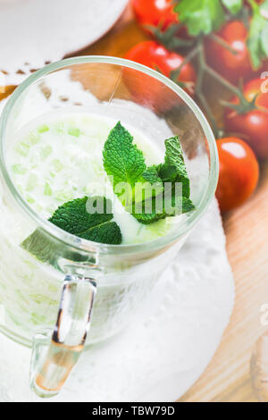 In casa le zucchine zuppa cremosa in tazza su uno sfondo luminoso Foto Stock