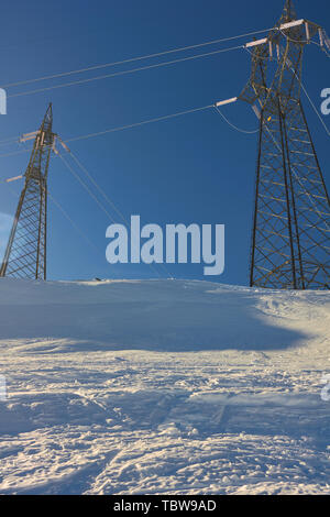 Elektricity nella neve - alimentazione di energia elettrica della torre del cavo nella parte superiore della montagna innevata in una giornata di sole - STAGIONE INVERNALE - sviluppo concetto di ecologia Foto Stock