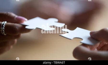 Close up multirazziale i membri del team aziende collegando i pezzi del puzzle Foto Stock