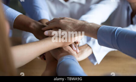 Close-up aziendali diverse persone mettere le mani insieme, che mostra il supporto Foto Stock