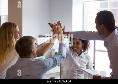 Multirazziale dipendenti dando alta cinque al briefing, che mostra l'unità Foto Stock