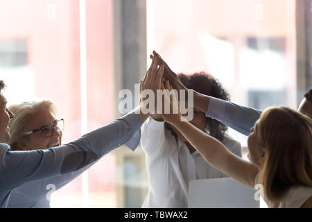 Close up diversi dipendenti dando alta cinque al meeting aziendale Foto Stock