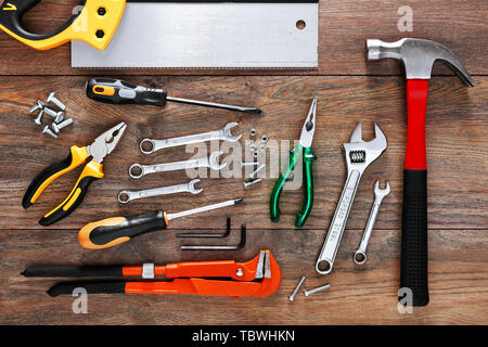 Un assortimento di strumenti di lavoro su sfondo di legno Foto Stock