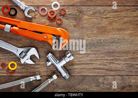Set di utensili per idraulici sul tavolo di legno dello sfondo. Close up vista dall'alto in basso con copia spazio. Foto Stock