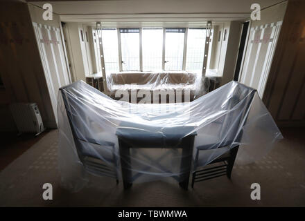 Una camera da letto con lenzuola protettive all'interno della Hill House di Charles Rennie Mackintosh a Helensburgh, come il National Trust for Scotland finire di installare i ÔBox' intorno alla casa. Foto Stock