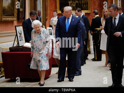 La regina Elisabetta II con il presidente statunitense Donald Trump visualizza una speciale mostra nella galleria di immagini di oggetti da collezione reale di importanza storica per gli Stati Uniti, a seguito di un pranzo privato a Buckingham Palace di Londra il giorno uno dei suoi tre giorni di visita di Stato nel Regno Unito. Foto Stock