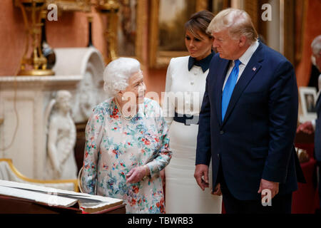 La regina Elisabetta II con il presidente statunitense Donald Trump visualizza una speciale mostra nella galleria di immagini di oggetti da collezione reale di importanza storica per gli Stati Uniti, a seguito di un pranzo privato a Buckingham Palace di Londra il giorno uno dei suoi tre giorni di visita di Stato nel Regno Unito. Foto Stock
