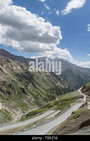 La foresta di plateau Panshan strada lungo il G217 Doku autostrada sotto il cielo blu e nuvole bianche in Xinjiang, Cina Foto Stock