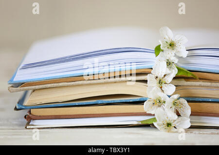 Aprire libri e bellissimi fiori sul tavolo, primo piano Foto Stock