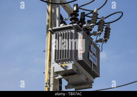 Primo piano linea di elettricità e l'elettricità post all cielo blu sullo sfondo Foto Stock