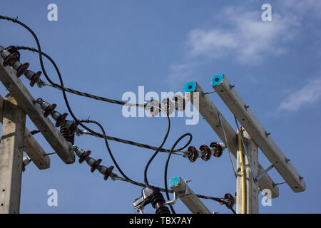 Primo piano linea di elettricità e l'elettricità post all cielo blu sullo sfondo Foto Stock