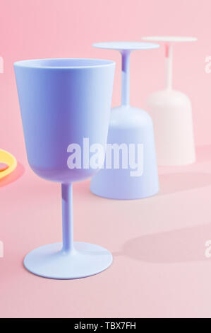 Colore luminoso picnic in plastica utensili. Rosa, giallo, blu nel recipiente. Foto in hard light. Spazio di copia Foto Stock