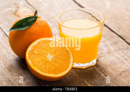 Spremuta di arancia fresca, un bicchiere di succo di frutta fresco e arance. Foto Stock