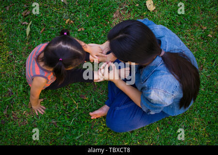 Ritratto di uno stile di vita la mamma e figlia in felicità all'esterno nel prato, Funny famiglia asiatica in un campo di riso. Immagine ad alta risoluzione gallery. Foto Stock