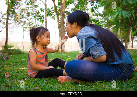 Ritratto di uno stile di vita la mamma e figlia in felicità all'esterno nel prato, Funny famiglia asiatica in un campo di riso. Immagine ad alta risoluzione gallery. Foto Stock