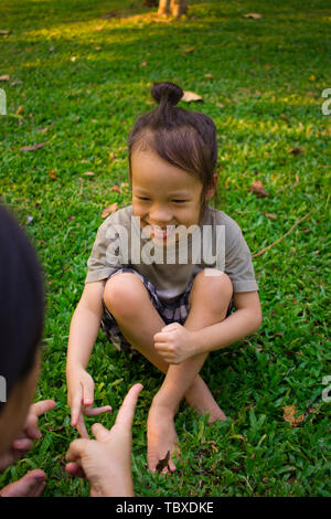 Ritratto di uno stile di vita la mamma e il ragazzo nella felicità all'esterno nel prato, Funny famiglia asiatica in un parco verde ad alta risoluzione galleria dell'immagine. Foto Stock