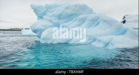 Un blu iceberg galleggianti sulla superficie dell'acqua. Foto Stock