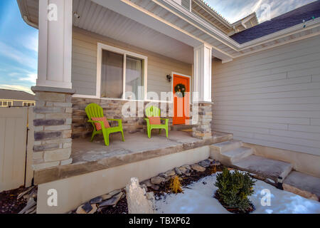 La facciata della casa con arancio brillante porta anteriore decorata con una ghirlanda di festa Foto Stock