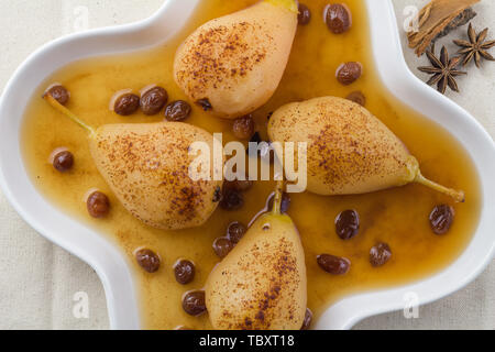 Pere affogato in raisin salsa alla vaniglia in piastra bianca - Spiced Pear backgroun - top view image Foto Stock