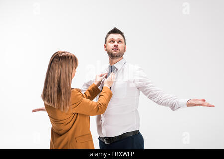 Donna in tuta la regolazione tirante del sovrappeso uomo gesti con le mani isolato su bianco Foto Stock
